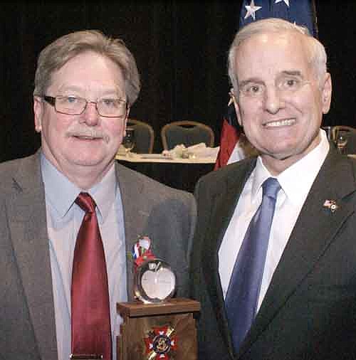 Dr. Greg W. Olson of Stewartville, a teacher in the Dover-Eyota School District, left, has been named the Veterans of Foreign Wars (VFW) Senior High School State Teacher of the Year for grades 9-12. Gov. Dayton, right, congratulates Olson.