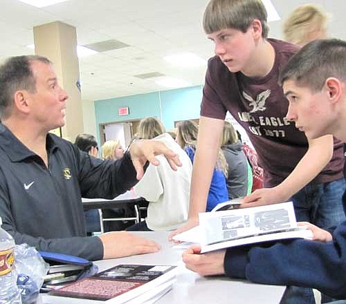 Bobby Petrocelli, left, meets with students after his motivational talk last week, including freshmen Cody Keefer, center, and Dylan Deetz.