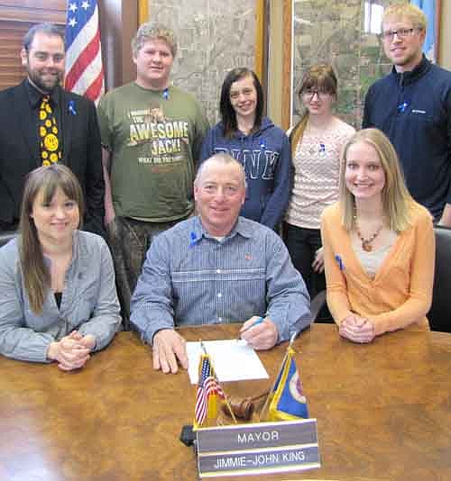 Mayor Jimmie-John King, seated in center, signed a proclamation last week declaring April "Child Abuse Prevention Month" in Stewartville. Allison Johnson, coordinator of the Crisis Nursery in Rochester, is seated at left. Linnea Borland, social work intern at the Crisis Nursery, is seated at right. Back row, from left, Rich Fakler of  Voices for Children, Ethan Meier, Nicole Thorson and Jessica Gorder, ROC (Rochester Off Campus)&#8200;students; and Kyle Belshan, ROC&#8200;teacher. ROC partners with the Crisis Nursery to fight child abuse.