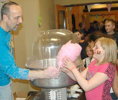 Gary Kadansky serves cotton candy to Alexis Harvey, 11, a fifth-grader at Central Intermediate School, at the Kids Extravaganza at Grace Evangelical Free Church on Saturday, April 19. Kids also made key chains and crosses, and had fun sliding down an inflatable slide.