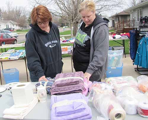 Dawn Heaser, left, and Dawn Miller, both of Rochester, browse among the items at Stewartville's citywide garage sale on Thursday morning, May 8. The two say they attend Stewartville's sale every year. "We're deal hunters," Miller laughed. "I need to feed my purse addiction."