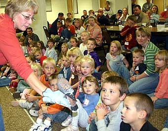 Sue Shockey of the Quarry Hill Nature Center displays an American kestrel to a group of children at the St. John's Wee Care potluck supper on Oct. 16. 