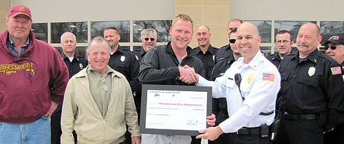 Mike Roe of Dekalb/Asgrow, center, presents Vance Swisher, Stewartville fire chief, with a $2,000 donation to the Stewartville Fire Department during the open house for Stewartville's new Fire Station on Saturday, April 26. Others standing in front, from left, include County Commissioner Matt Flynn, Stewartville Mayor Jimmie-John King and Steve Wolf of the Stewartville Fire Department.  Firefighters plan to apply the $2,000 toward the purchase of a new $5,700 aluminum trailer.