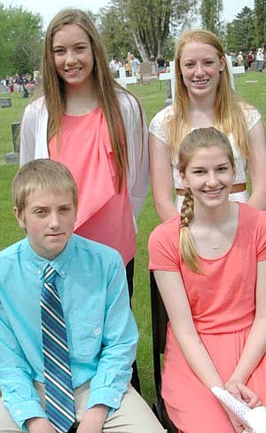 Hundreds of local and area residents honored U.S. veterans on&#8200;Memorial Day, Monday, May 26. At far left above, clockwise from lower left, Erik Sistad, Lori Bailey, Emily Rinken and Erin Ross, eighth graders, were the featured speakers at the annual ceremony at Woodlawn Cemetery.