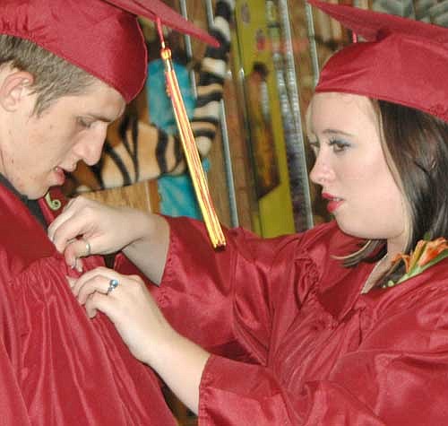 About 112 members of the Stewartville High School class of 2014 received their diplomas at the annual commencement ceremony at the SHS gym last Friday evening, June 6. Here, Karina Baltis, right, helps Austin Atkinson prepare for the ceremony.