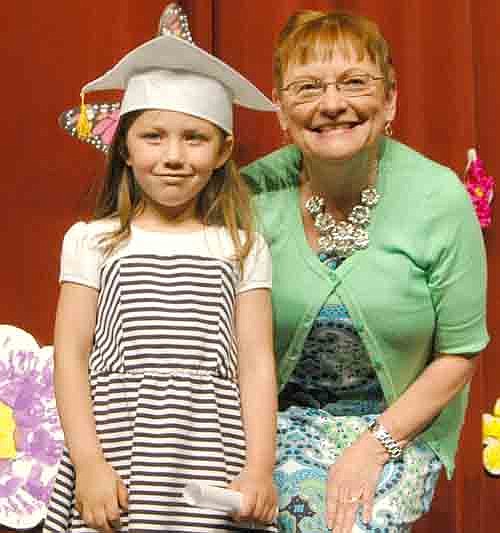 YOUNG GRADUATES -- Nancy Pedersen, school readiness teacher, poses with graduate Aubrey Apland at the Stewartville School Readiness graduation program at the Performing Arts Center on Tuesday, June 3.