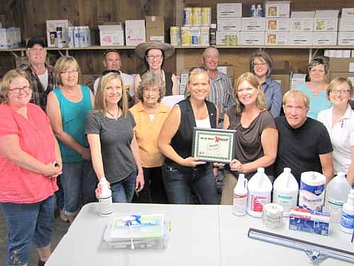 Beth Schmidt of the Stewartville Area Chamber of Commerce, fourth from right, presents a Business Xposed! certificate to Paulette and Bruce Teigen, third and second from right, and Melissa Sue Leuning, far right, of Teigen Paper last week. Others who visited the downtown business include, in front, from left, Gwen Ravenhorst, Chamber administrator; Arvilla Boehm, Chris Dahle and Margaret Clark. Back row, from left, Bob Baker, Brett Struhar, Theresa Hornberg, Jimmie-John King, Stacy Schimmel and Cheryl Roeder.
