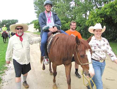 Dan Mellen of Freeport, Ill., a camper at the Ironwood Springs Christian Ranch's annual Sports Camp, rides a horse guided by, not necessarily in order, Emily Stensvold, co-wrangler at Ironwood Springs; Tucker Speltz, assistant program director; and Tom Barry, volunteer.