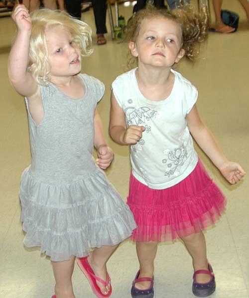 About 50 children enjoyed the music as the Zinghoppers hosted a dance party at the Stewartville Civic Center last Wednesday, June 25. Here, Addy Blake, left, and Betsy Langseth, 3-year-olds from Stewartville, stay in step with the music. The Stewartville Public Library sponsored the program, which promoted reading.