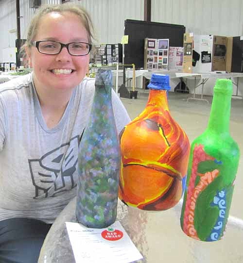 Katie Miller earned a red ribbon for her bottle art project. She used wheat paste to attach paper to the bottles, then covered the paper with bright colors and attractive designs.