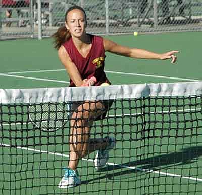 Maddie Grimm charges to volley a ball that just barely clears the net during Stewartville girls varsity tennis action last fall.