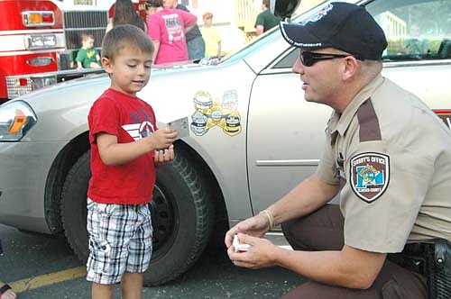 About 350 residents from Southern Hills and Northridge Place attended the annual National Night Out celebration at Southern Hills on Tuesday, Aug. 5. Ayden Salem, 4, who lives in Southern Hills, accepts a baseball card from Zak Breitenbach, Stewartville's community oriented policing (COPS) deputy. Breitenbach has said that National Night Out gatherings fight crime by giving residents a chance to get better acquainted with their neighbors. Those who know their neighbors well are more likely to look out for each other and recognize others who don't belong in the neighborhood, he said.