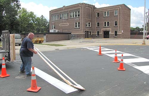 Kevin Heydt of the city of Stewartville's public works department added a new coat of paint to a crosswalk near Central Intermediate School last week. Students in the Stewartville School District will return to school on Tuesday, Sept. 2.