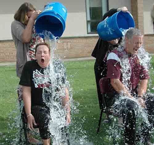 Local school administrators answered the ALS Ice Bucket Challenge near Stewartville High School last Tuesday morning, Aug. 26. From left, Sheila McNeill, principal of Central Intermediate School, and Matt Phelps, principal of Bonner Elementary School, wail in pain as the icy water hits their bodies. Tim Malone, associate principal of Stewartville Middle School; Darcy Lindquist, associate principal of Stewartville High School; and Steve Gibbs, principal of Stewartville High School and Middle School, all of whom are not pictured, also answered the Ice Bucket Challenge.