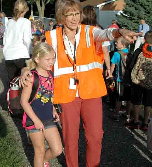 Students returned to Stewartville schools last Tuesday morning, Sept. 2. Here, Lynn Langseth, a paraprofessional, points the way for first grader Grace Meyer.