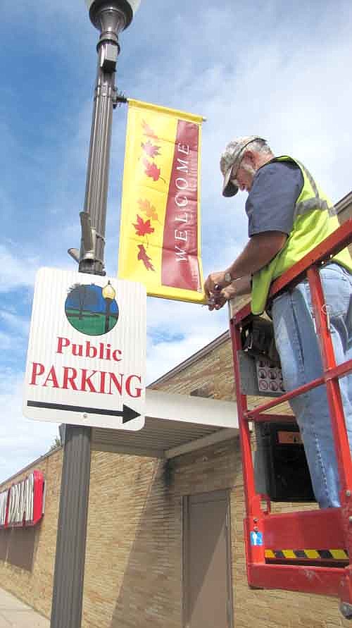 Scott Priebe, public works employee for the city of Stewartville, took down the summer signs and installed the autumn "Welcome to Stewartville" signs along Main Street last week.