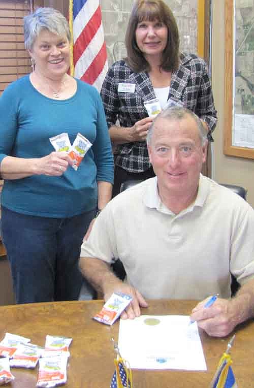 Mayor Jimmie-John King, seated, signed a proclamation declaring Saturday, Sept. 27 "Peanut Day" in the city of Stewartville. Behind the mayor are Mary Brouillard, left, and Kim Brown of  the Stewartville Kiwanis Club.