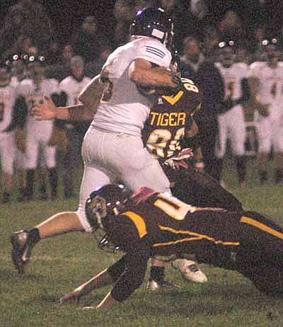 At left, linebacker Jamie Gehling (No. 44) dives and defensive end Chye Stecher (No. 80) reaches to wrap up Rochester Lourdes running back Zach Hillman during Stewie's 32-14 homecoming game loss last Friday evening, Oct. 3.