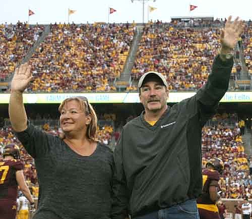 Lori and Cliff Feltis, family farmers in Stewartville, wave to the crowd after being announced as the Minnesota Corn Growers Farm Team Family of the Game at the Sept. 20 Minnesota Gophers football game.