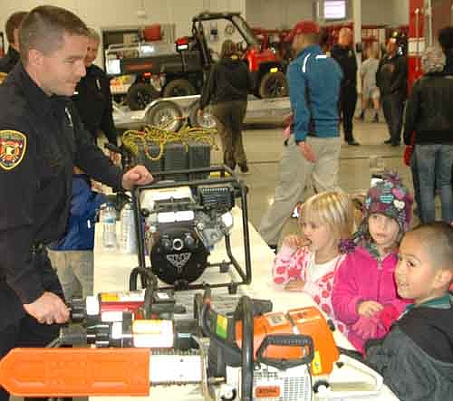 Stewartville firefighter Nathan Ramaker, above left, showed the tools of the firefighting trade to scores of children at the Stewartville Fire Department's annual open house last Wednesday, Oct. 8.