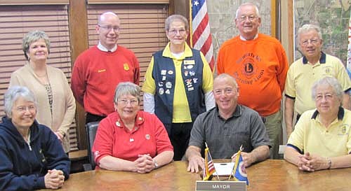 Mayor Jimmie-John King, seated second from right, signed a proclamation last week declaring Saturday, Oct. 25 as the second of the two White Cane Days in Stewartville for 2014. Among the members of the Stewartville Morning Lions Club who will seek donations that day for those with various eye diseases include, front row, from left, Sheila Majerus, Kay Tvedt, chair of White Cane Day, Mayor King and Carol Mrotek. Back row, from left, Cheryl Roeder, Robert Hruska, Jan Antonson, Clair Mrotek and Len Griffith.