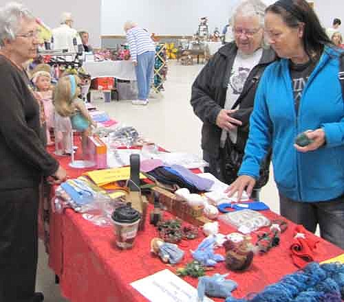 Nancy Henke of Stewartville, left, sold American Girl doll clothes, scarves, snowmen and other odds and ends at the Stewartville Center for Active Adults' Crafts & More event at the Stewartville Civic Center on Saturday,&#8200;Oct. 18. Janice Amos of Stewartville, center right, and her daughter Gina look over the items on Henke's table. Bev Noble of the Center for Active Adults said that the Center made about $650 in profit from the event. Twenty vendors sold a wide variety of items, including jellies, lefse, scarves, wreaths, soap, fall decorations and crocheted and knitted items. All proceeds will go to the Center for Active Adults, Noble said.