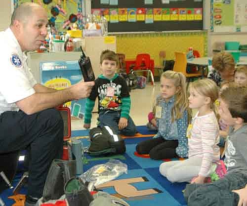 Vance Swisher, Stewartville fire chief, left, talks with kindergartners, from left, in front, Gavin Minor, Claire Bunne, Morgyn Manion and Peyton English. Lucas Peter, another kindergartner, can be seen  in the background.