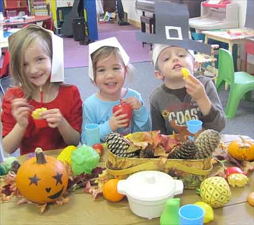 Children at the Stewartville Child Care Center re-enacted the first Thanksgiving with a simulated feast last week. From left are Keira Heiman, Juliana Perkins and Alex Miller. The Child Care Center is affiliated with the Stewartville Christian Church.