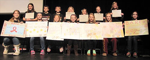 Sixth graders at Stewartville Middle School made posters highlighting the lessons they learned from the D.A.R.E. (Drug Abuse Resistance Education) class they attended during the first quarter of the 2014-15 school year. Students who were honored for their posters at last week's D.A.R.E. culmination ceremony include, front row, from left, Meghan Kosmala, Jaidyn Brower, Sarah Oeltjenbruns, Evelyn Van Ess, Mary Picket, Sydney Van Moer and Rachel Husgen. Rachel was also honored for her essay. Rory Scott, another student honored for her poster, is not pictured. Students who read their essays at the culmination ceremony include, back row, from left, Campbell Gunderson, Ben Trenary, Dawson Brinkman, Tessa Lanzel, Miah Mikel, Cydney Van Tassel and Elizabeth Willenborg.