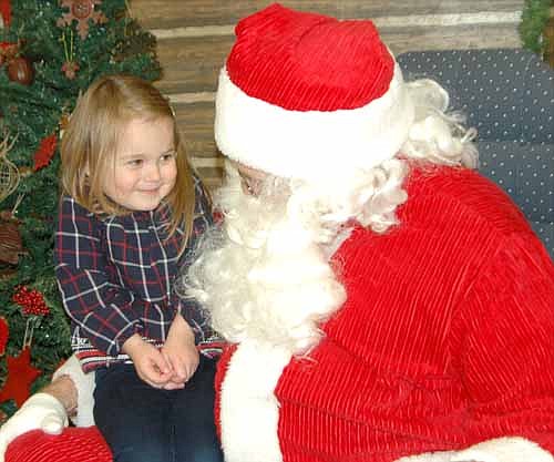 Jenavieve Hepner, 3, gives Santa Claus a smiling shrug as she tries to think of the presents she wants for Christmas at the Stewartville Civic Center on Saturday morning, Dec. 6. Jenavieve is one of hundreds of local and area children who visited Santa during the Stewartville Kiwanis Club's annual Pictures with Santa event.