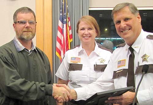 Troy Helget of Racine, left, accepts a special recognition award from Dave Mueller, Olmsted County sheriff, and Stacy Sinner, director of detention services at the Olmsted County Adult Detention Center, at the annual Olmsted County Sheriff's Office awards ceremony at the Government Center in Rochester on Tuesday evening, Dec. 9.