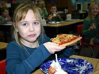 102.5 The Fox Radio delivered pizza to Kim Whiting's second-grade students at Bonner Elementary School on Wednesday, Jan. 9.  The radio station named Whiting its Teacher of the Month after Tanner Olson, one of Whiting's students, submitted a letter describing why Whiting is such a good teacher. Here, student Tiffany Waugh displays a slice of pizza. 
