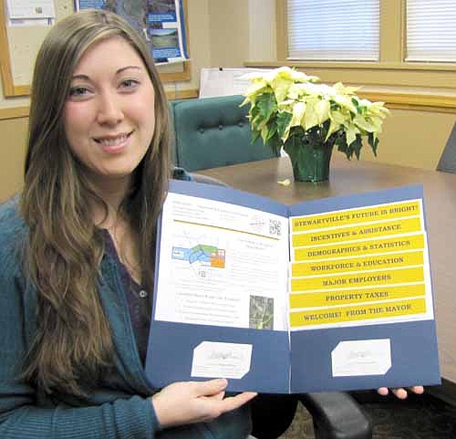 Joya Stetson, a community and business development specialist for Community & Economic Development Associates (CEDA) of Chatfield, displays an updated folder of information now available to area individuals and businesses interested in pursuing Stewartville as a place to live or start a business.