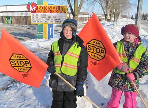 Anthony Nelson, left, and McKenna O'Neill, third graders at Bonner Elementary School, dressed warmly for their jobs as School Patrol crossing guards near the school last Tuesday afternoon, Jan. 13.  Both enjoy their duties. "It's awesome," Anthony said. "I get to protect people." McKenna agreed. "You get to help people so they don't get run over," she said.