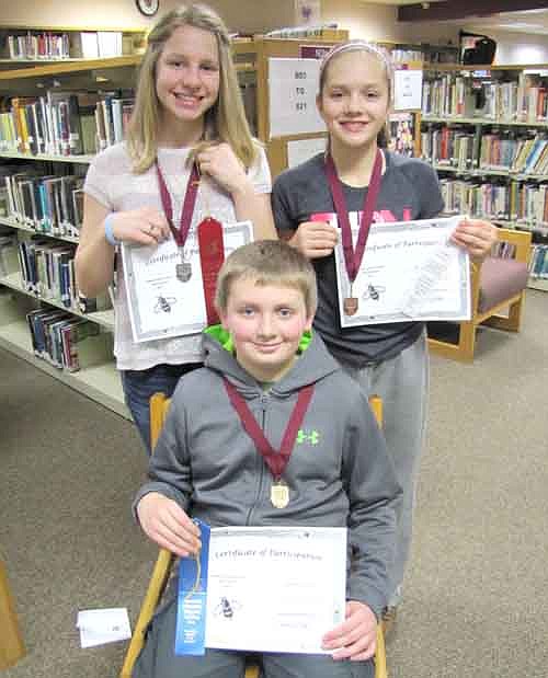 Top finishers in the annual Stewartville Middle School Spelling Bee include, seated, Noah Laures, a sixth grader, first place; and back row, from left, Grace Ramaker, a seventh grader, second place; and Grace Waltman, another seventh grader, third place. Noah correctly spelled "benefactor" in the final round to win the contest, which was held at the Performing Arts Center on Tuesday, Jan. 20.