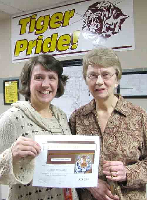 Diane Bergland, right, accepts a Tiger Token from Darcy Lindquist, associate principal of Stewartville High School. Bergland was honored for her work with a homebound student. 