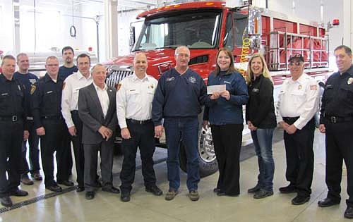 All American Co-op of Stewartville and CoBank, an industry partner, have donated $5,400 to the Stewartville Fire Department, which used the funds to buy two Rae Systems QRAE gas monitors and one yet-to-be purchased Eclipse thermal imaging camera. Kathleen Roberts of CoBank, fourth from right, shares the check with Glenn Lutteke of All American Co-op, fifth from right, during a recent presentation at the Stewartville Fire Department. Others who attended the ceremony included, from left, firefighters Aaron Jones, Nate Petrich, Jamey Kime, Brandon Dohlman, and Josh Podein, Mayor Jimmie-John King, Fire Chief Vance Swisher, Beth Pagel of All American Co-op, and firefighters Mike Podein and Dale Olson.