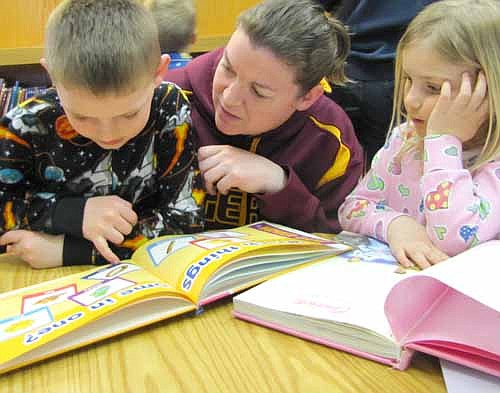 Jaymie Carolan of Stewartville joins her children Cody, 6, left, and Kaitlyn, 4, for a reading session during the annual St. John's Wee Care Pajama Party at the Stewartville Public Library on Tuesday evening, March 10.