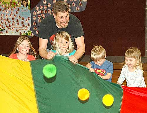 Children from the Stewartville School District and Community Education Early Childhood Learning Center enjoyed "Daddy and Me Gym and Pizza Night" at Central Intermediate School last Thursday evening, March 19. Nathan Petersen, one of many dads who attended, helps his daughter, Amelia, bounce balls on a parachute as children, from left, Mattie Helwig, Zach Rich and Makayla Hysell assist.
