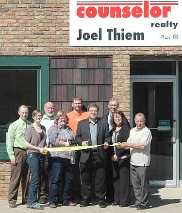 The Stewartville Area Chamber of Commerce welcomed Joel Thiem Counselor Realty to the local business community with an official ambassador visit last week. From left are Andy Mai, Melissa Sue Leuning, Chamber president; Rick Dahl, Gwen Ravenhorst, Chamber administrator; Joel Thiem (cutting ribbon),  John Senjem, Bridget Dahle and Mayor Jimmie-John King.
