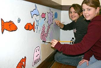 In keeping with the Stewartville School District's "Fish" philosophy, Nora Luskey's art students, including Kaylee Muller, foreground, and Meghan Schmitz, began painting an undersea world on Central Intermediate School's lower walls last week. 