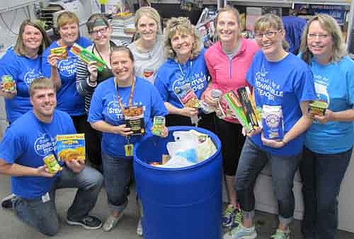 Teachers and staff members at Bonner Elementary School display some of the items they donated to the Channel One Food Bank during a recent food drive. Front row, from left, are Jeff Johnson, Courtney Fakler and Julie Rupprecht. In back, from left, are Lindsay Dick, Bert Lentz, Jenny Roberts, Kelly Norman, Kathy Pinke-Thorson, Jen Oelkers and Maryan Gisler. District teachers and staff members took part in the food drive from May 4 through May 8.