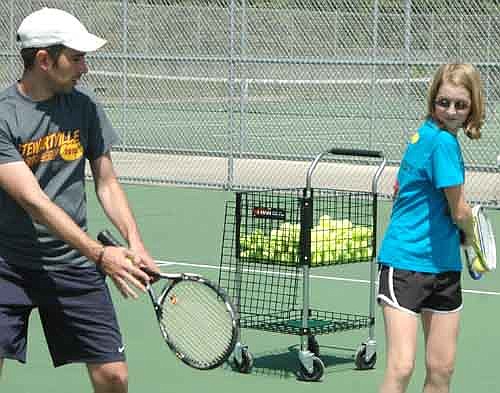 Tiger tennis camp coach Nick Johnson demonstrates a backhand drill as Victoria Nienow executes the proper motions at the 2015 Stewartville Community Ed youth tennis camp, June 8-11 at the SHS courts.
