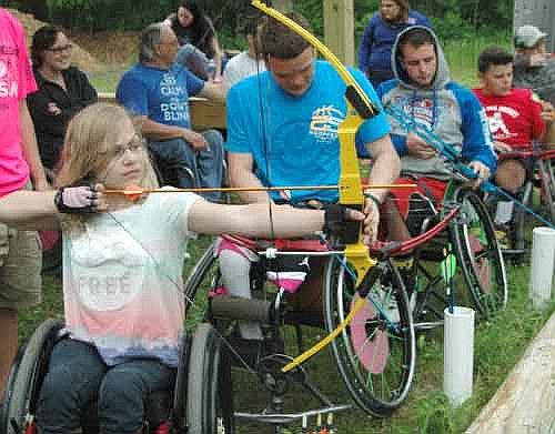 Emily Sullivan of Le Sueur, Minn., in the foreground, and many others with disabilities practiced their archery skills at the 29th annual National Wheelchair Sports Camp at Ironwood Springs Christian Ranch last week. Campers participated in a variety of other activities as well, including tennis, softball, water skiing and horseback riding. Bob Bardwell, director of Ironwood Springs Christian Ranch, said that 70 individuals with disabilities attended this year's camp.
