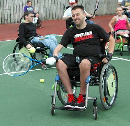 Alex Wallschlaeger of Hortonville, Wis. practices his forehand at the National Wheelchair Sports Camp at Ironwood Spring Christian Ranch last week. David Wheaton, who played professional tennis from 1988 to 2001, worked with the campers on their skills.