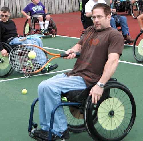 Derek Benson of Washington D.C. watches the ball go off the sweet spot of his racket during a tennis drill at the National Wheelchair Sports Camp last week.