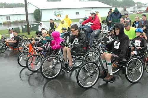 Trent Dubberke of Marshalltown, Iowa (No. 288), center, and Marcus Urban of Eagan, Minn., far right, focus on the race ahead during a rainy start to the National Wheelchair Sports Camp's Wheels & Heels of Fire event on Saturday morning, June 13.