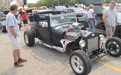 Car enthusiasts check out a 1926 Ford Model T Coupe at the annual Stewie Cruisers Car Show. The 89-year-old car has 454 horsepower.