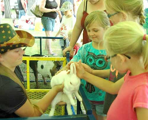 Madison Funk , 8, in blue shirt. and her friends Trinity Poncelet, 9, center, and Tiffany Poncelet, 6, pink shirt, pet a bunny at the Stewartville FFA Petting Zoo.