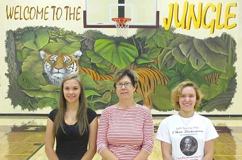 Anyone who visits the Stewartville High School gym in the coming days, weeks and months will know that it is the home of the Stewartville Tigers. Rhonda Baldner, art teacher at Stewartville High School, center, and her students Sarena Lee, left, and Kelsey Meyer, 2015 graduates of Stewartville High School, worked for more than 60 hours each, or a combined 180 to 200 hours, to complete "Welcome to the Jungle," a mural on one of the walls of the SHS&#8200;gym. "It was a lot of hours," said a smiling Baldner. "It was a lot of kissing that wall."